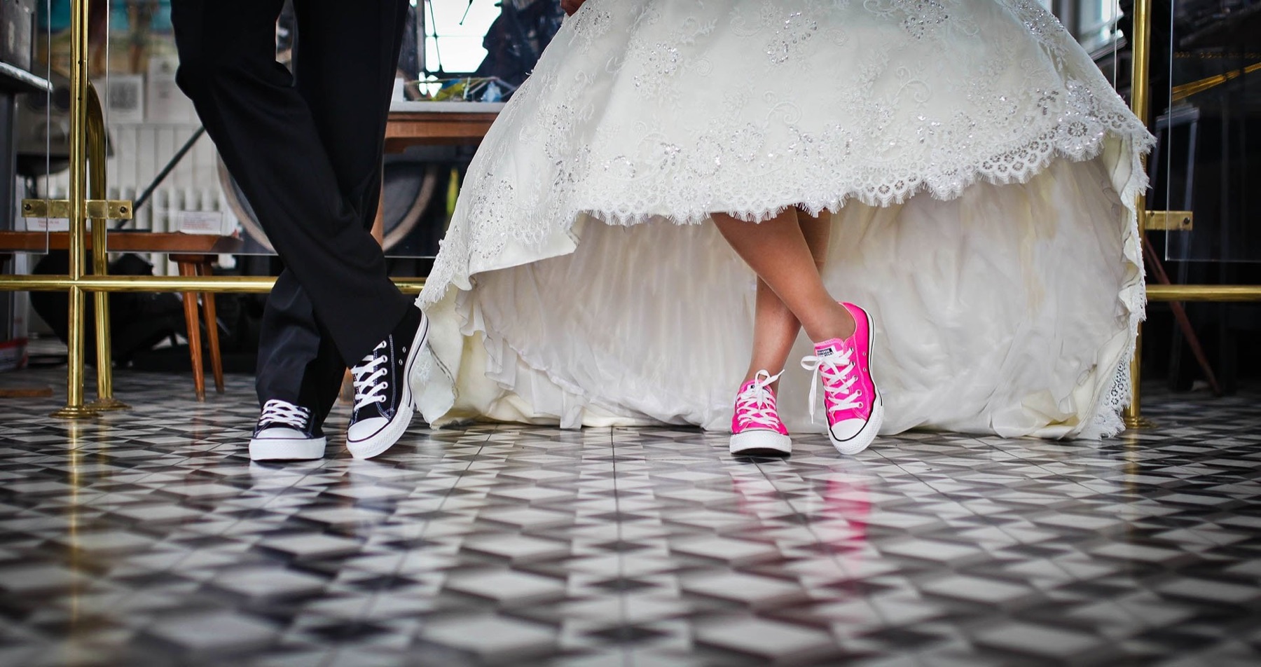 A bride in pink sneakers on a checkered dance floor