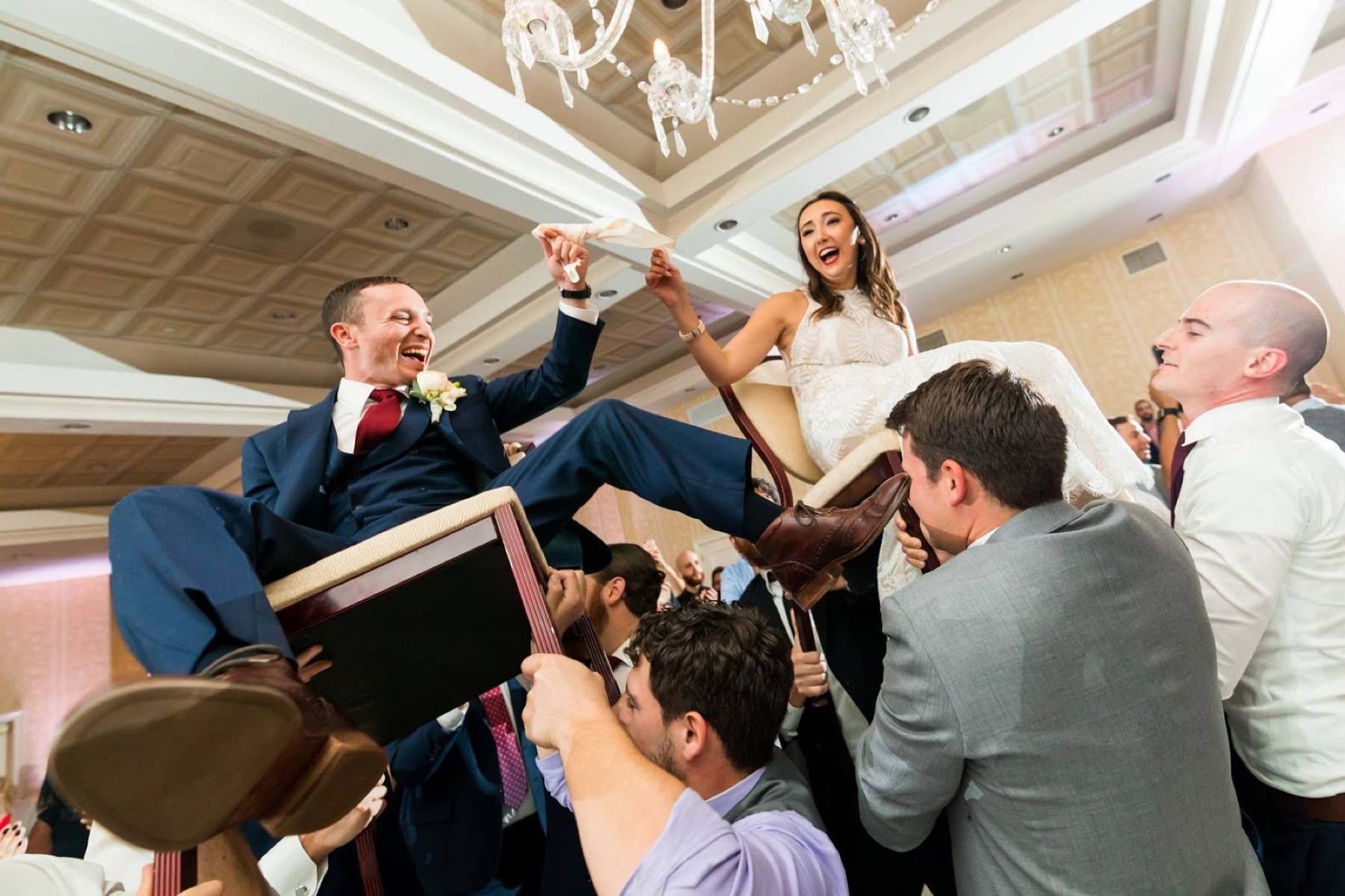 Newlyweds lifted on chairs during the hora